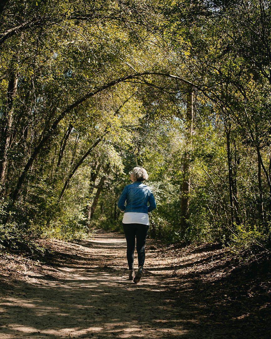 woman walking through the woods enjoying nature